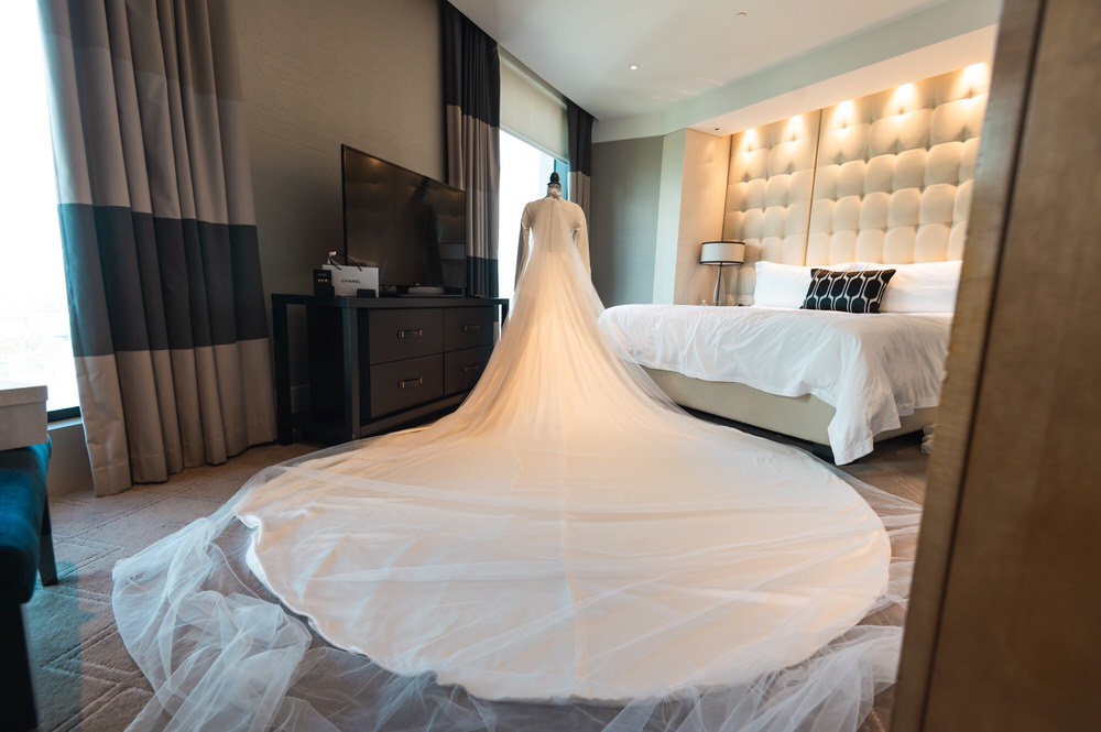 Bride wears custom gown with Cathedral length train and veil