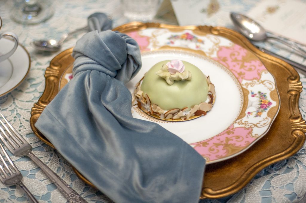 Dusty blue napkin sits on top of a vintage pink plate
