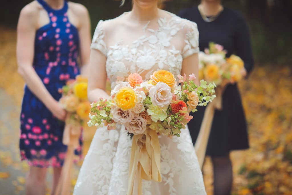 Brightly colored spring wedding bouquet with orange and green flowers 