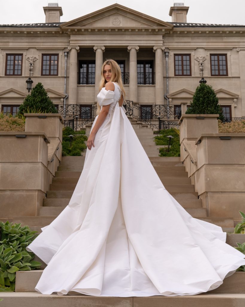 Satin bridal ballgown with off-the-shoulder sleeves and cathedral train