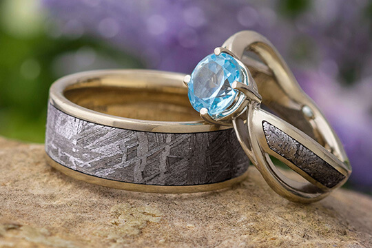 Meteorite and gold wedding band and meteorite engagement ring with blue gemstone