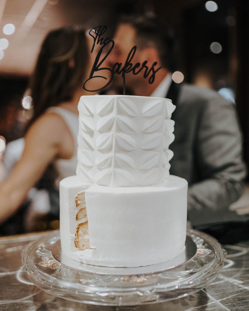 2-tier white wedding cake with leaf imprints on top layer