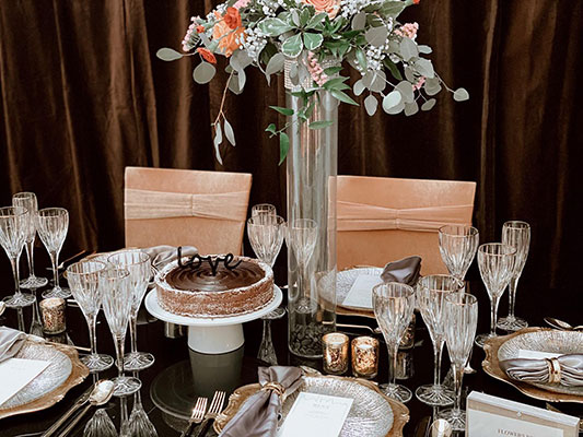 Single-tier chocolate ganache wedding cake on wedding table