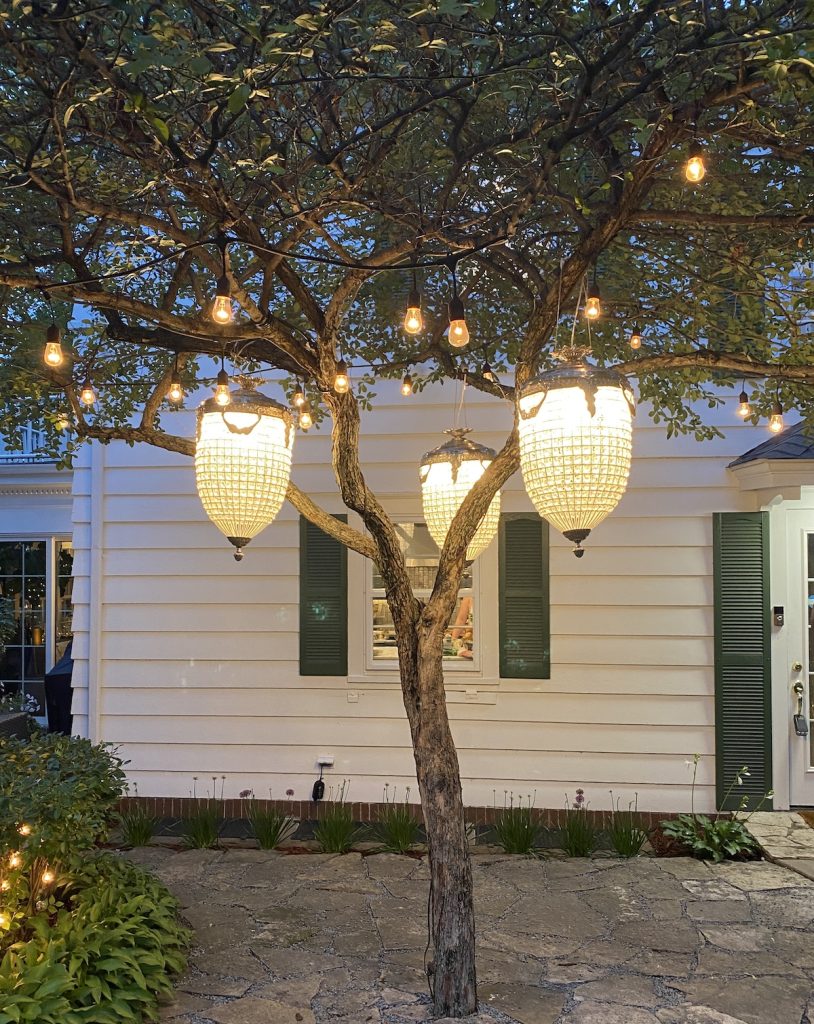Chandeliers hang from trees outside for Gatsby-themed engagedment party
