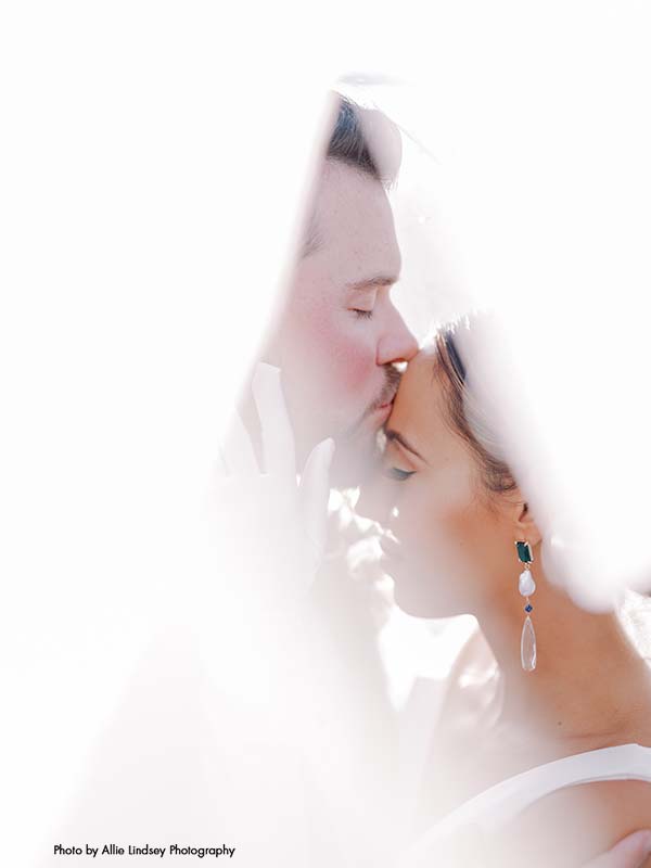 Groom kisses bride on forehead