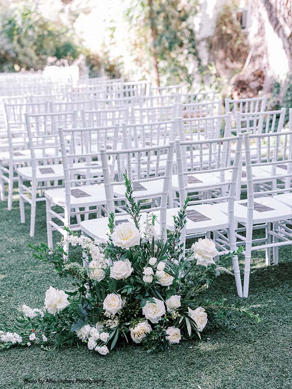 White chiavari chairs with white and and green ceremony decor