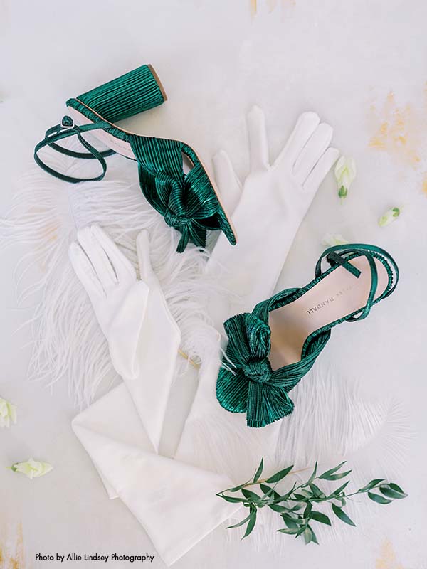 Green bridal shoes lay next to elbow-length bridal gloves