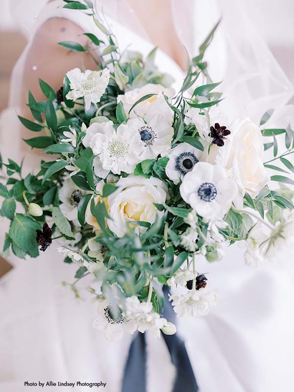Bridal bouquet with white flowers, anemone, and greenery