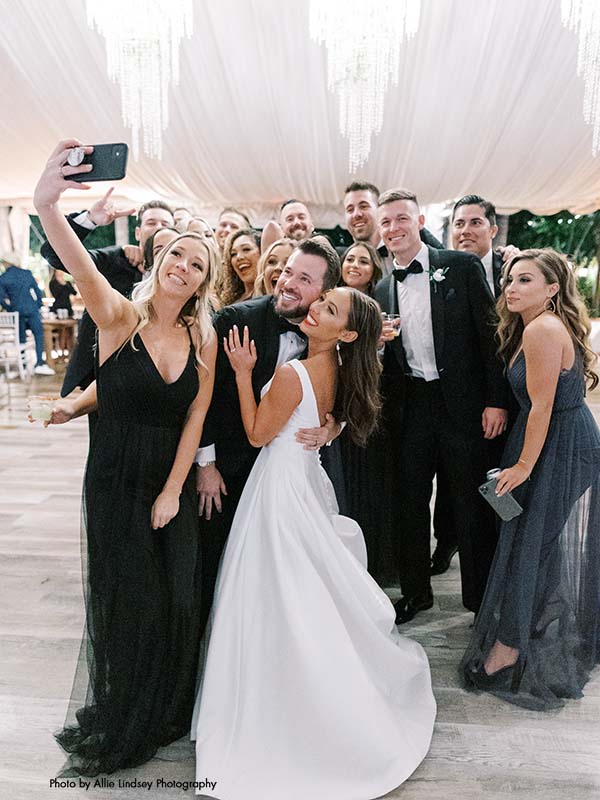 Bridesmaid takes picture with wedding party