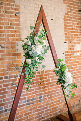 Eucalyptus floral swag on a wooden triangle arch