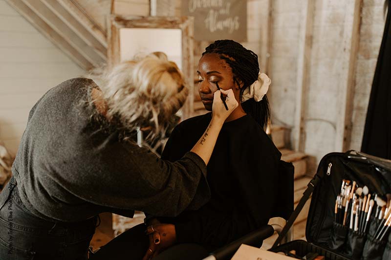 Makeup artist applies eyeshadow on bride