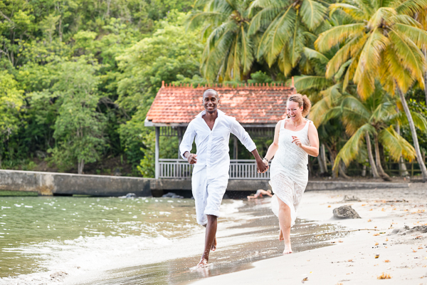 Bride and groom run on beach at destination wedding