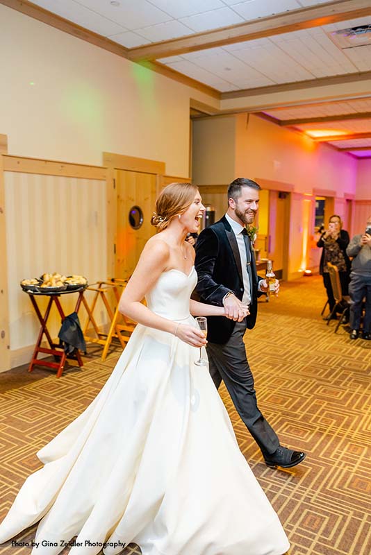 Bride and groom enter reception in ballroom