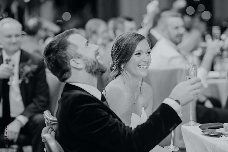 Bride and groom laugh during wedding speeches