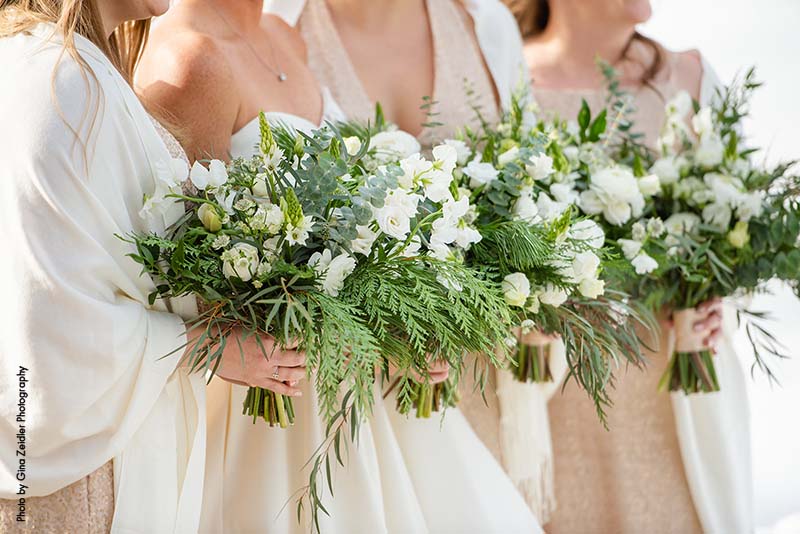 Winter wedding bridesmaid's bouquets with white flowers and pine needles