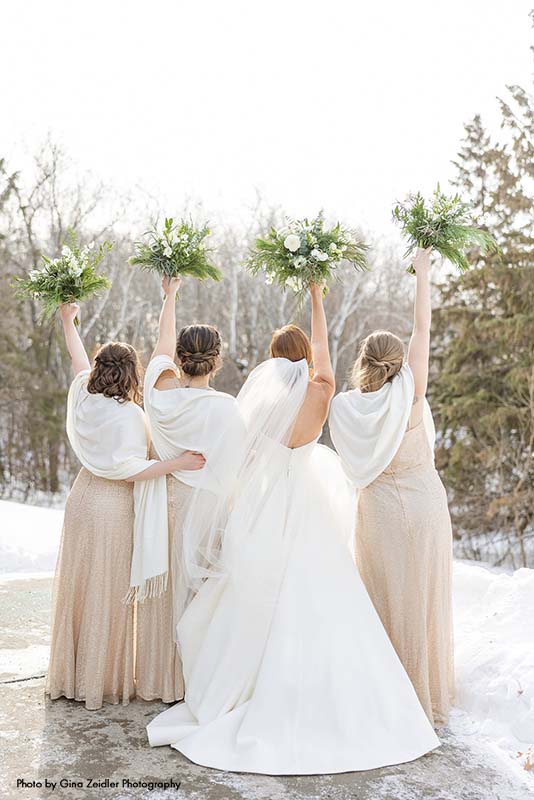 Bridesmaids in gold dresses pose with bride