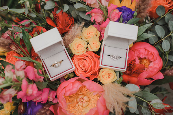 Wedding rings sit on bed of colorful flowers