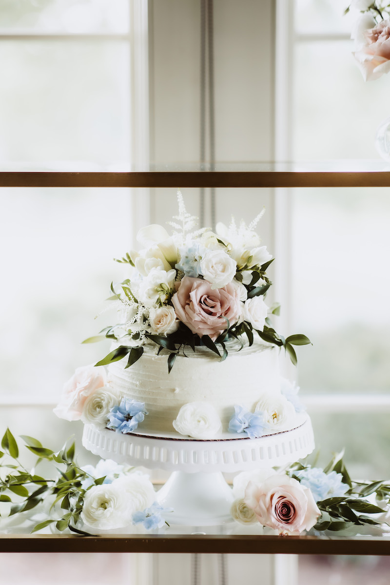 Two-tier wedding cake with pastel floral topper