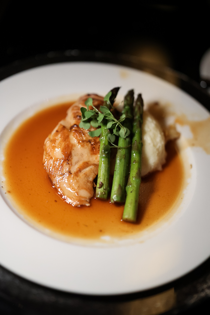 Pan-seared chicken wide a side of mashed potatoes and asparagus