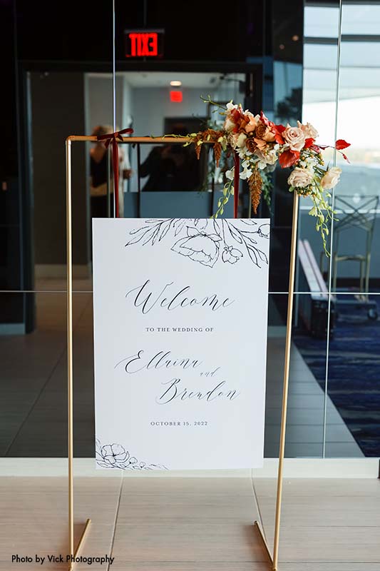 Wedding welcome sign hangs on copper stand