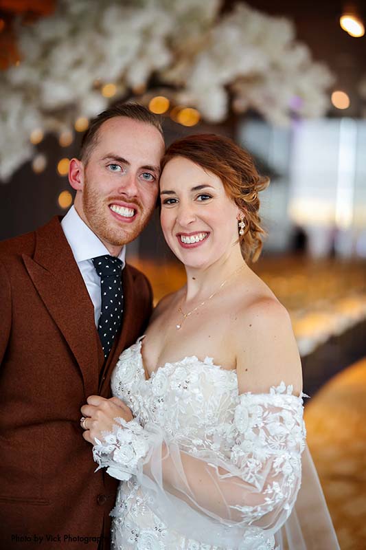 Bride in gown with detachable sleeves and groom in brown suit
