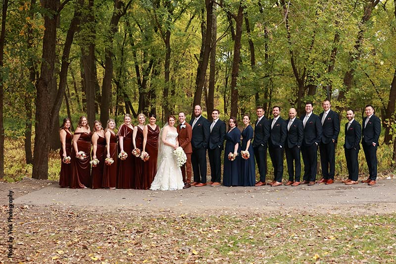 Large wedding party in navy and burgundy colors pose