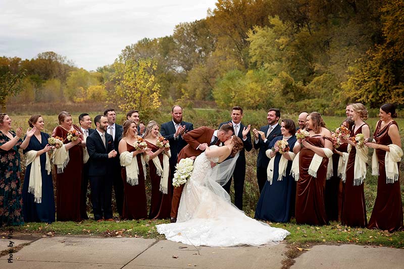 Bride and groom pose with large wedding party