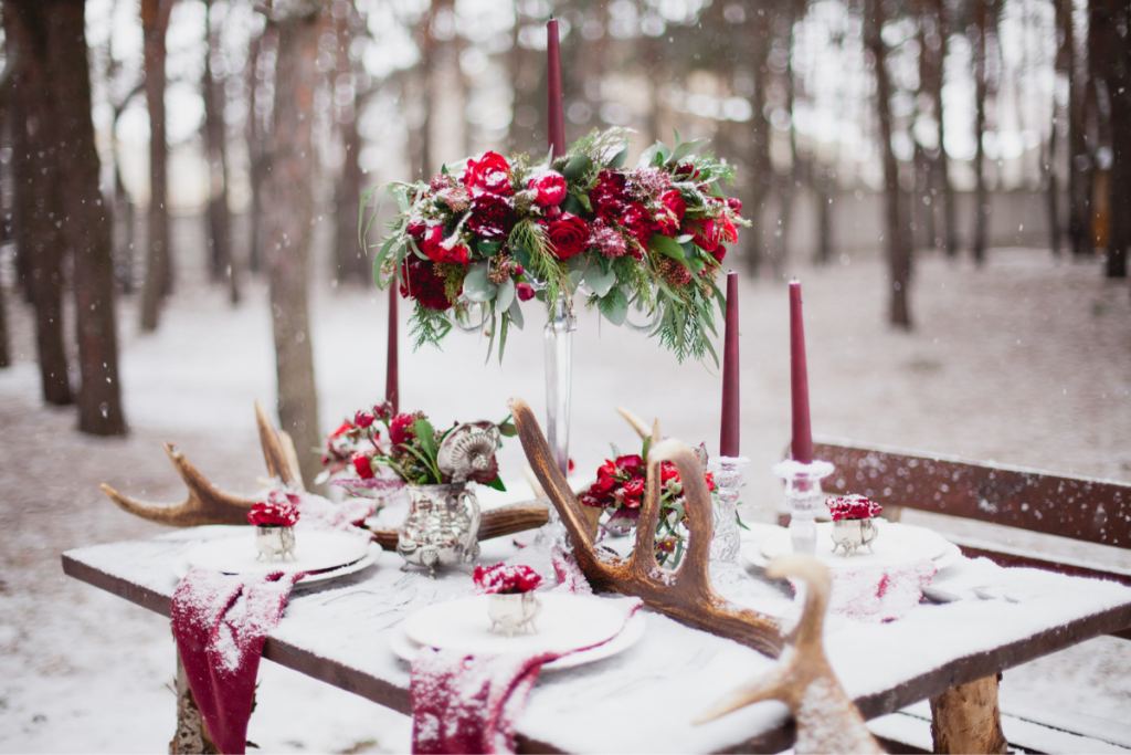 Winter wedding table scape with green and red floral
