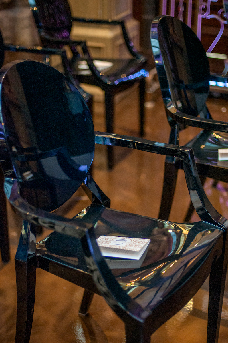 Black acrylic chairs at wedding ceremony